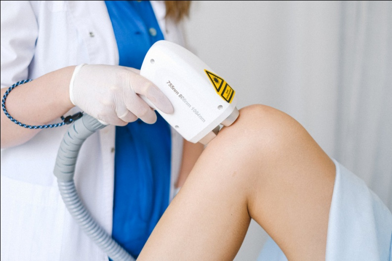 Laser therapy being done on a woman’s knee
